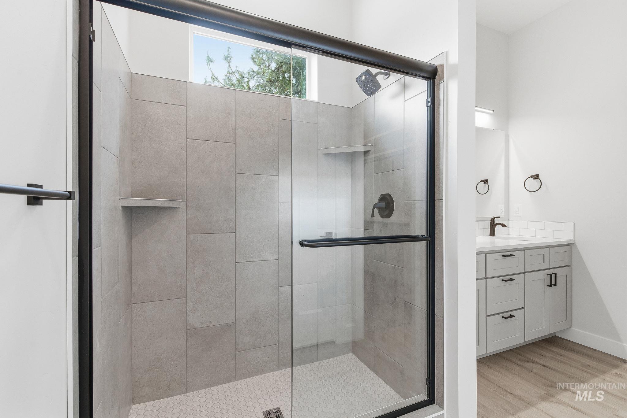6821 West Ustick Road Boise, ID 83704 - Photo 34 of 42 Bathroom featuring a shower stall, vanity, and light wood-style flooring
