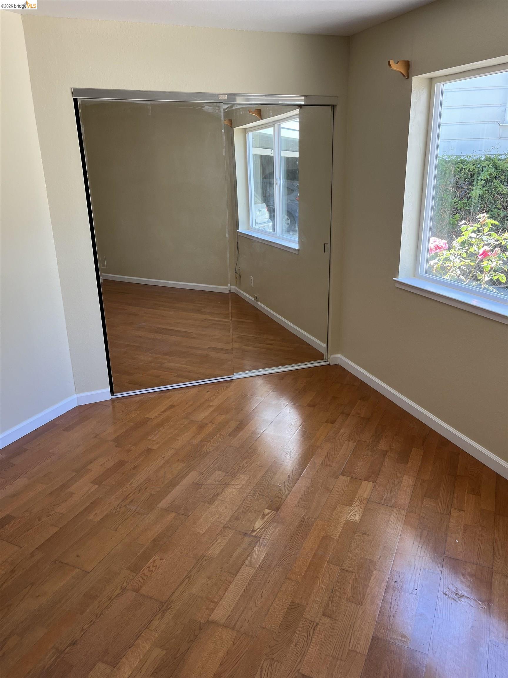 2018 Ninth Street, Unit B Berkeley, CA 94710 - Photo 5 of 5 an empty room with wooden floor and windows