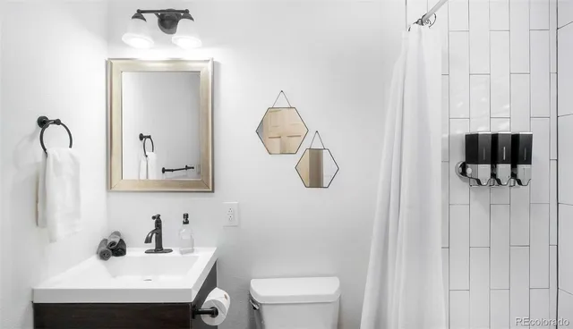 a bathroom with a sink vanity and toilet