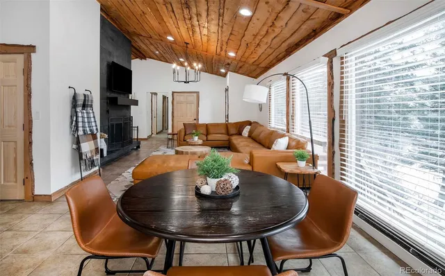 a dining room with furniture wooden floor and a chandelier