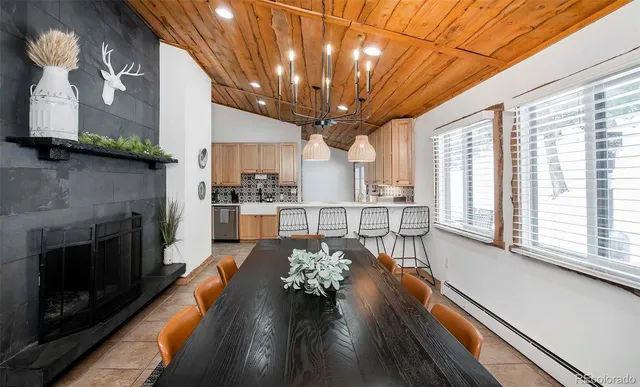 a living room with stainless steel appliances granite countertop furniture and a fireplace