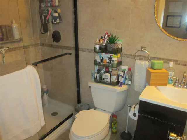 a white toilet sitting next to a bathroom sink and a mirror