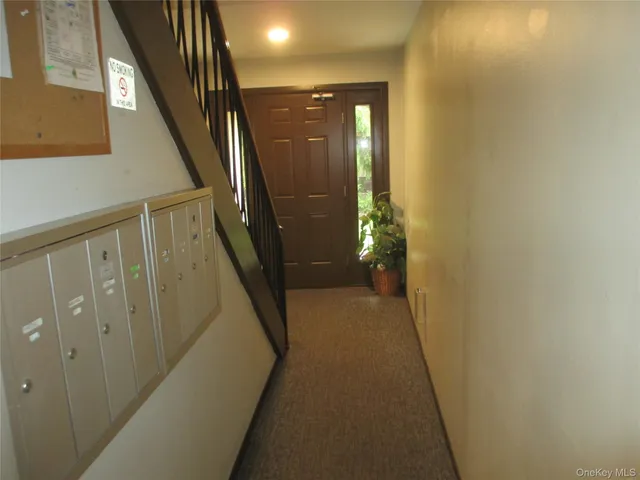 a view of a hallway with wooden floor and stairs