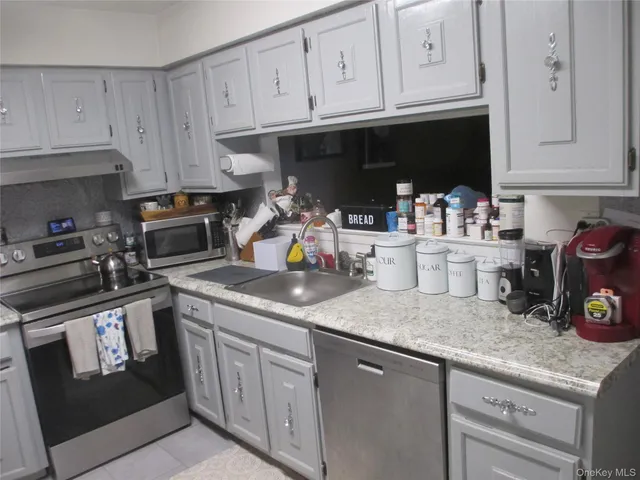 a kitchen with granite countertop white cabinets and sink