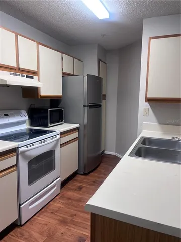 a kitchen with a stove a refrigerator and a sink