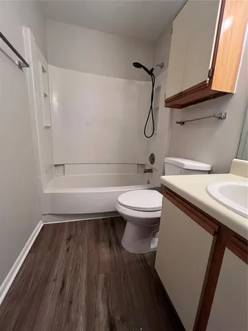 a bathroom with a granite countertop toilet sink and mirror