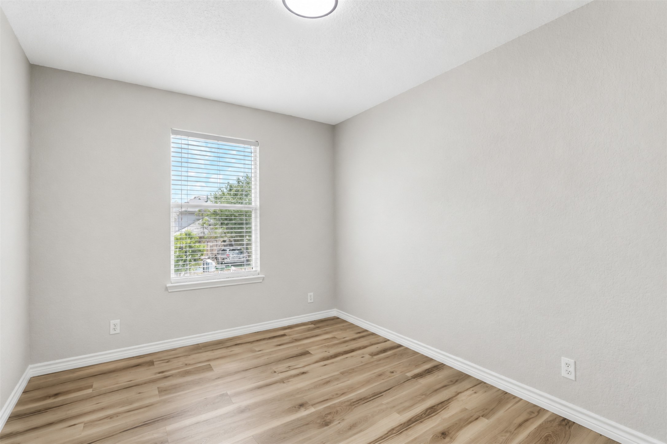 4523 Secure Lane Austin, TX 78725 - Photo 32 of 40 A well-lit room showcases durable laminate flooring, offering versatile space for various needs.