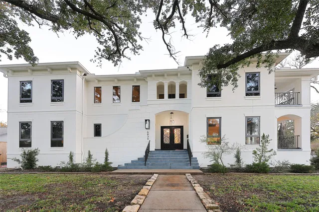 a view of a white house with large windows