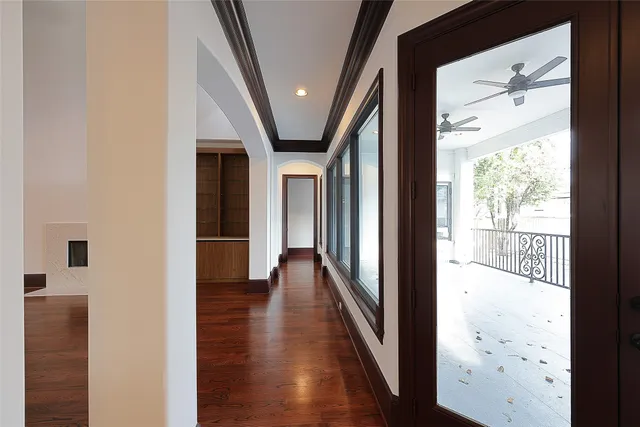 a view of a hallway with wooden floor and staircase