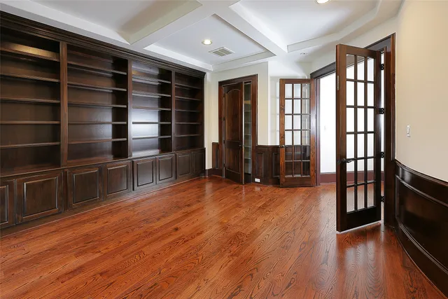 a view of empty room with wooden floor and windows