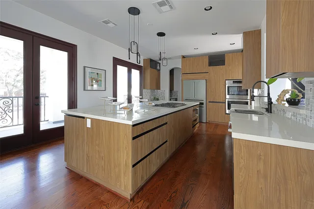 a large kitchen with stainless steel appliances granite countertop a lot of counter space and wooden floor