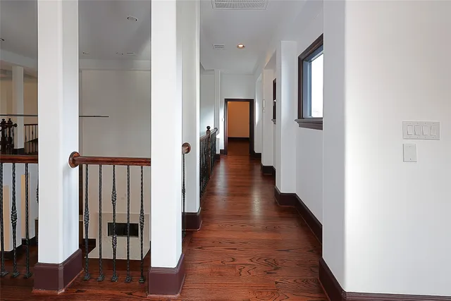 a view of a hallway with wooden floor and staircase