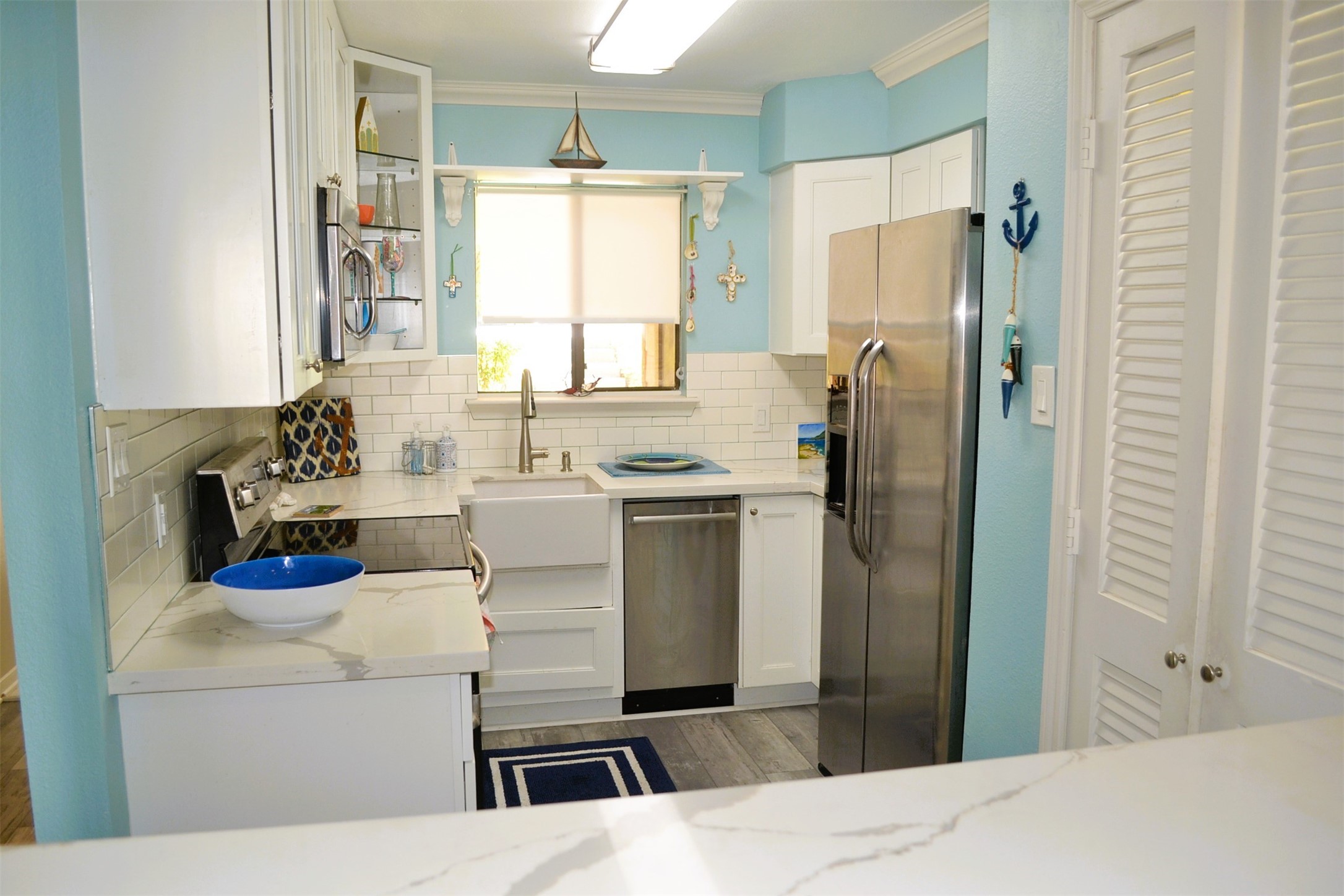 102 Lakeview Terrace, Unit D Conroe, TX 77356 - Photo 13 of 44 a kitchen with stainless steel appliances a refrigerator sink and white cabinets