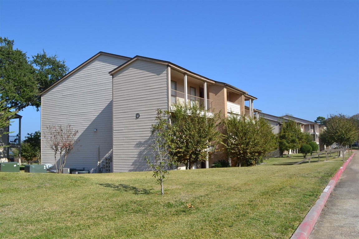 102 Lakeview Terrace, Unit D Conroe, TX 77356 - Photo 29 of 42 a backyard of a house with large trees