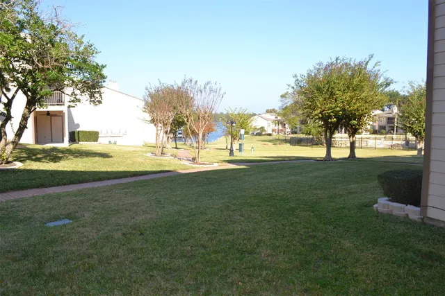 a view of a swimming pool with a lawn chairs under an umbrella
