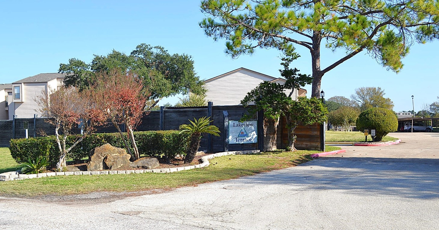 102 Lakeview Terrace, Unit D Conroe, TX 77356 - Photo 33 of 42 a front view of a house with a yard garage and outdoor seating