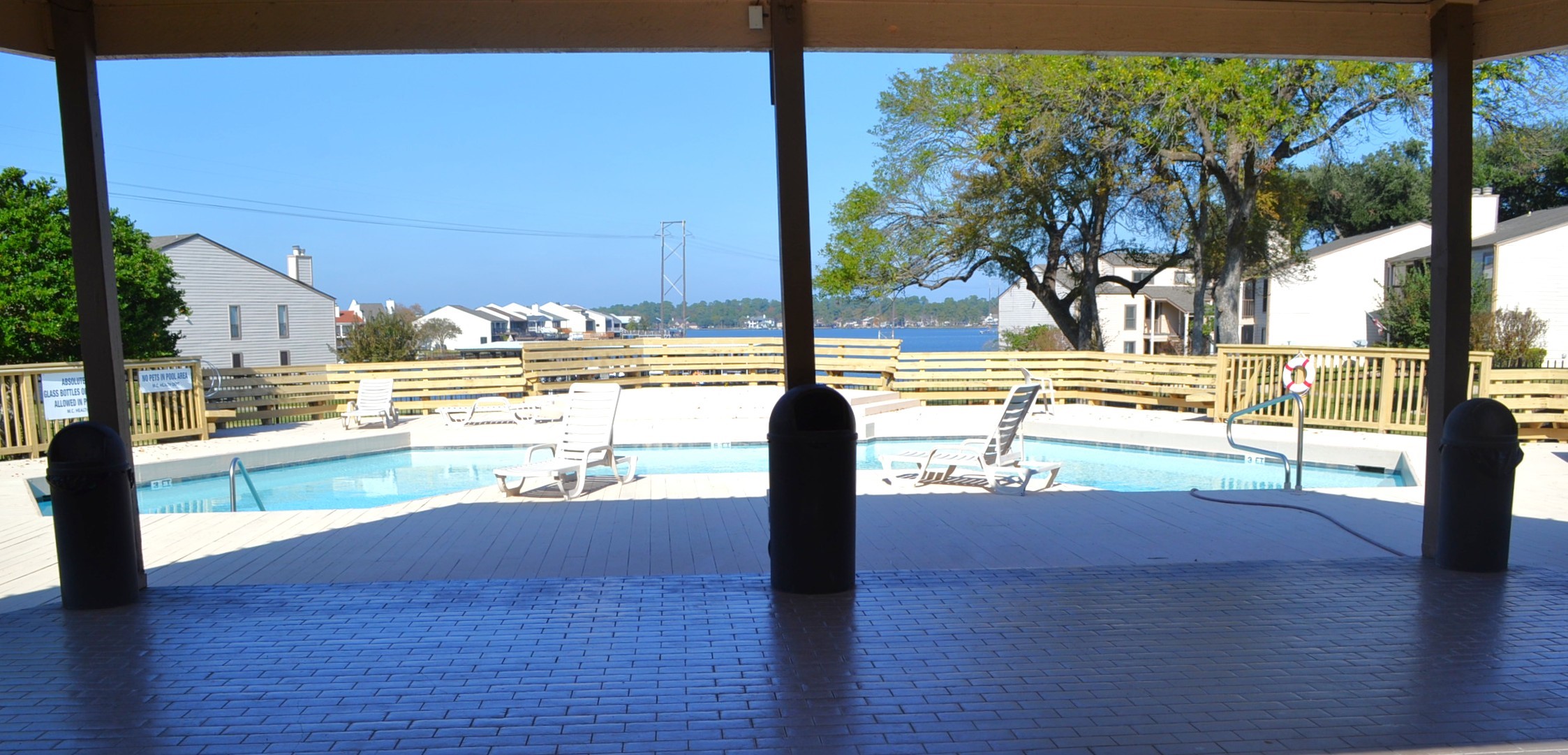 102 Lakeview Terrace, Unit D Conroe, TX 77356 - Photo 39 of 44 a view of a swimming pool with a lawn chairs under an umbrella
