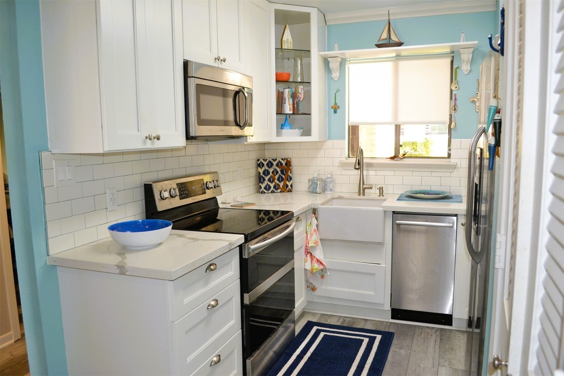 102 Lakeview Terrace, Unit D Conroe, TX 77356 - Photo 5 of 42 a kitchen with a stove microwave and refrigerator