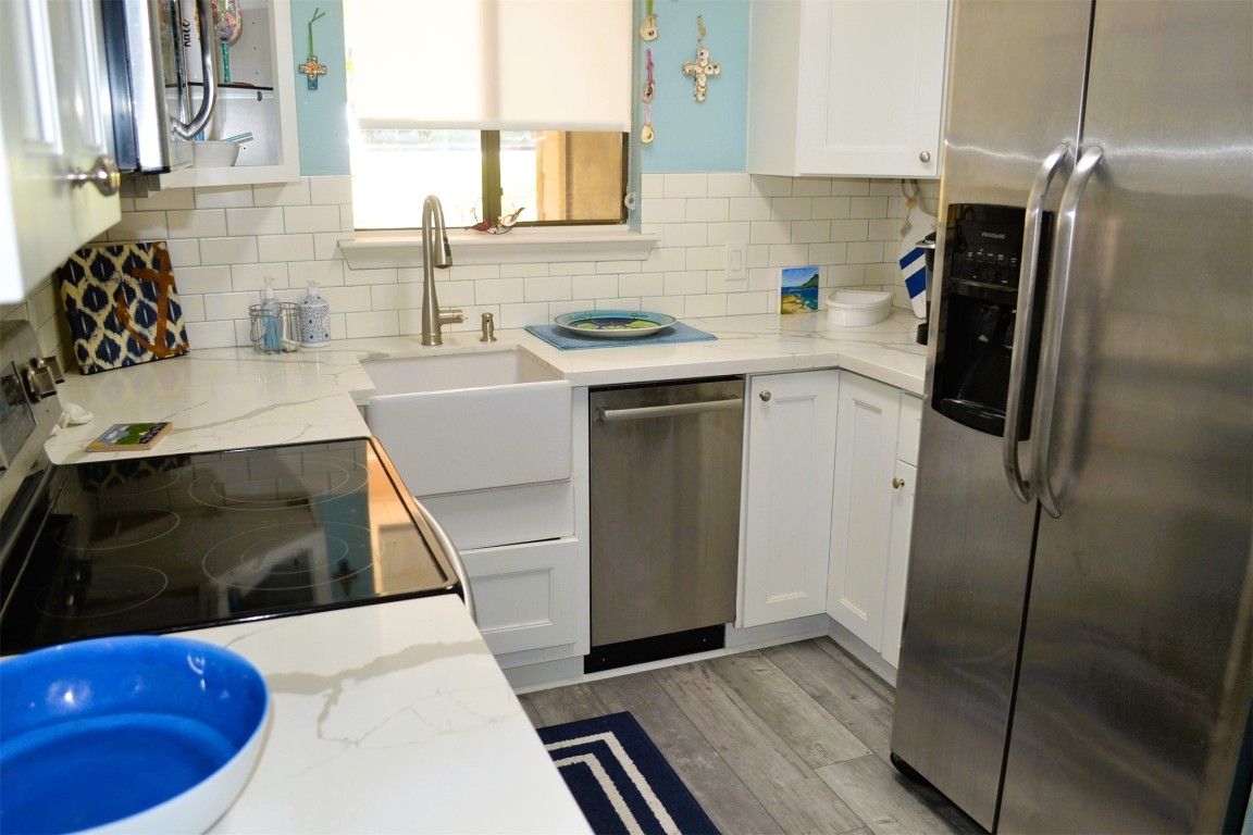 102 Lakeview Terrace, Unit D Conroe, TX 77356 - Photo 7 of 42 a kitchen with a sink and a refrigerator