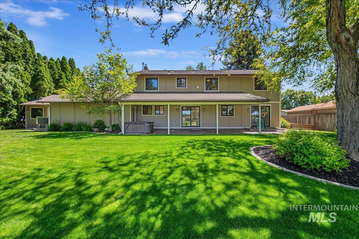 599 Pebble Beach Way Eagle, ID 83616 - Photo 35 of 44 Expansive green lawn with mature trees and a covered patio