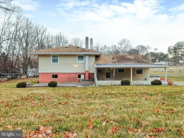 an aerial view of a house with a yard and large tree