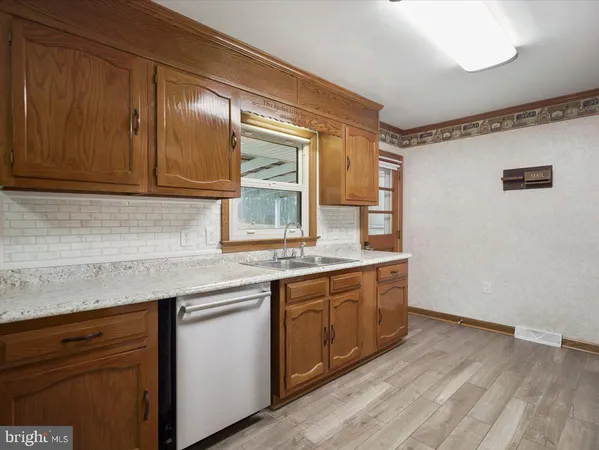 a kitchen with granite countertop stainless steel appliances sink and wooden cabinets