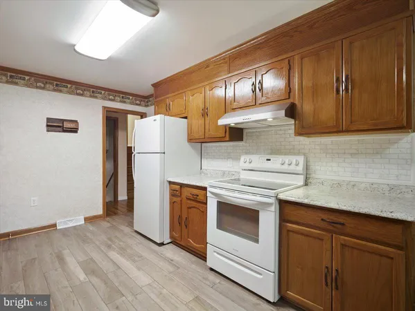 a kitchen with a stove refrigerator and cabinets
