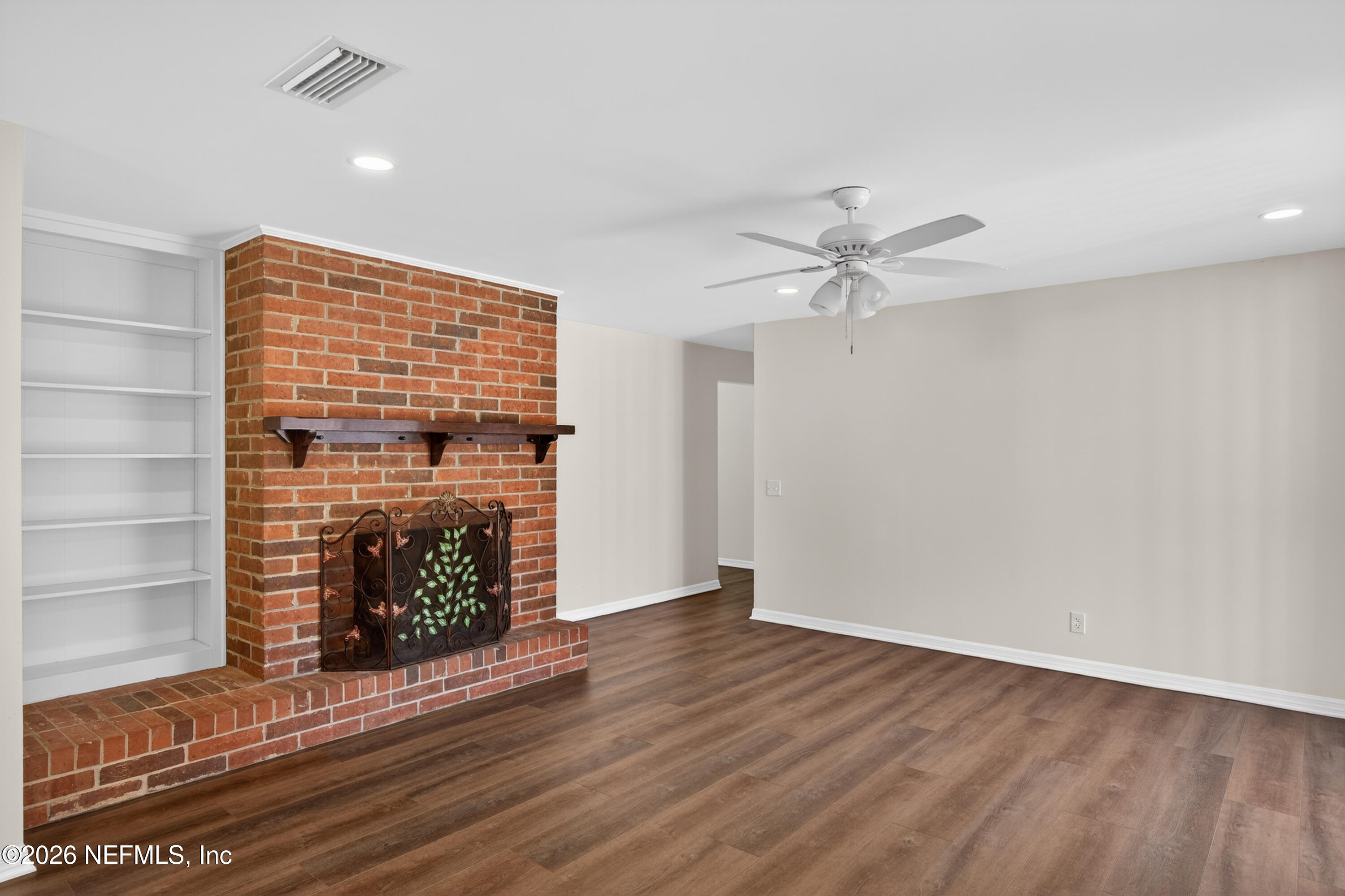 2766 Greenridge Road Orange Park, FL 32073 - Photo 14 of 30 an empty room with wooden floor a fireplace and windows