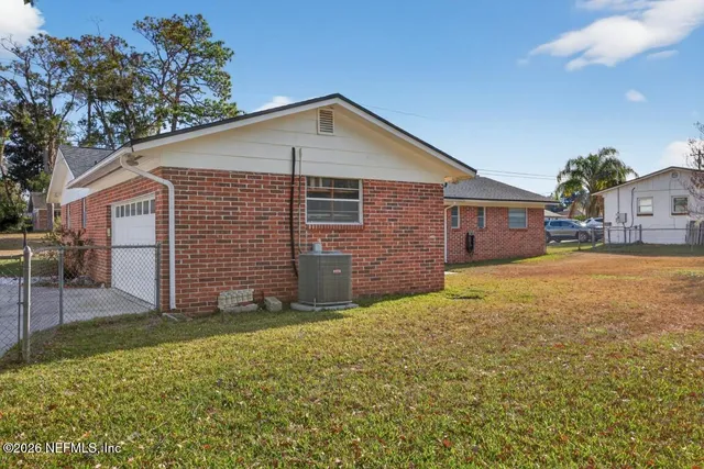 a front view of house with yard and trees in the background