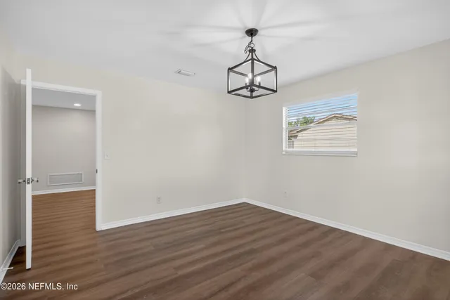 a view of a room with wooden floor carpet and a window