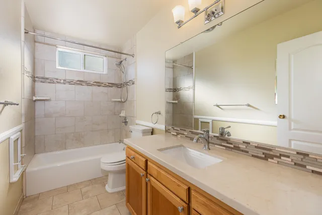 a bathroom with a granite countertop sink a toilet and bathtub