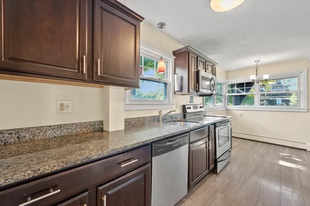 a kitchen with granite countertop stainless steel appliances a sink and cabinets