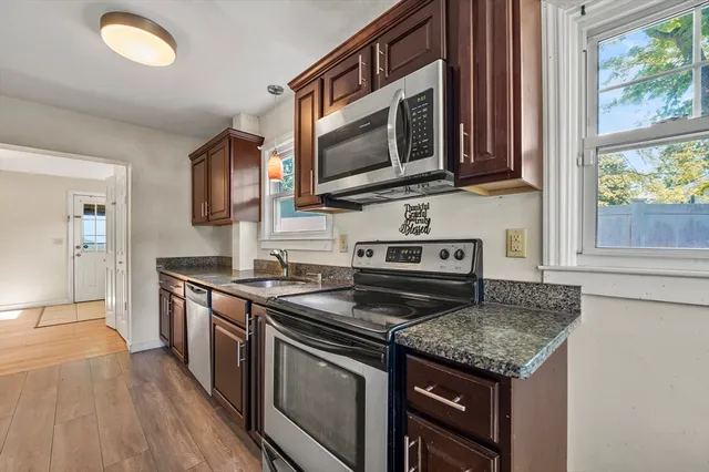 a kitchen with stainless steel appliances granite countertop a stove microwave and sink