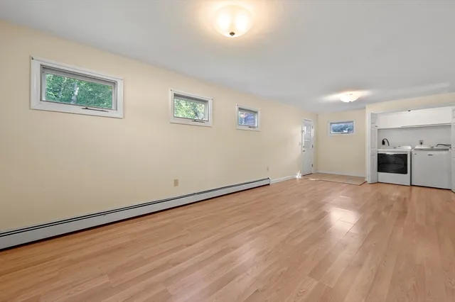 a view of empty room with wooden floor and window