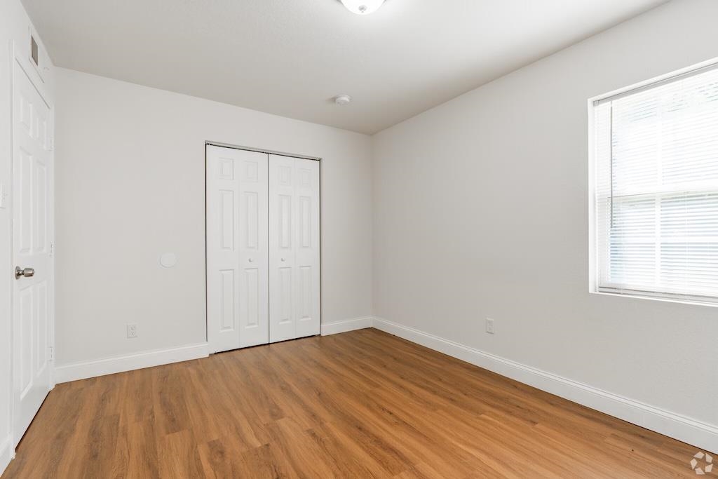3236 Millington Road Memphis, TN 38127 - Photo 13 of 31 Bright interior space featuring wood-finish flooring, white walls, a single window with blinds, a bi-fold closet, and a paneled door