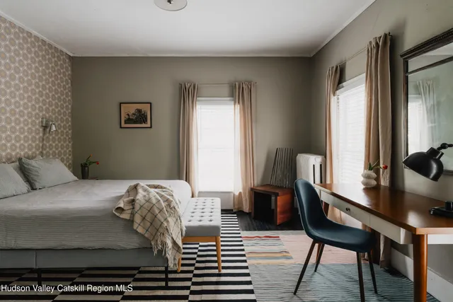 a bedroom with a bed and a bookshelf with wooden floor