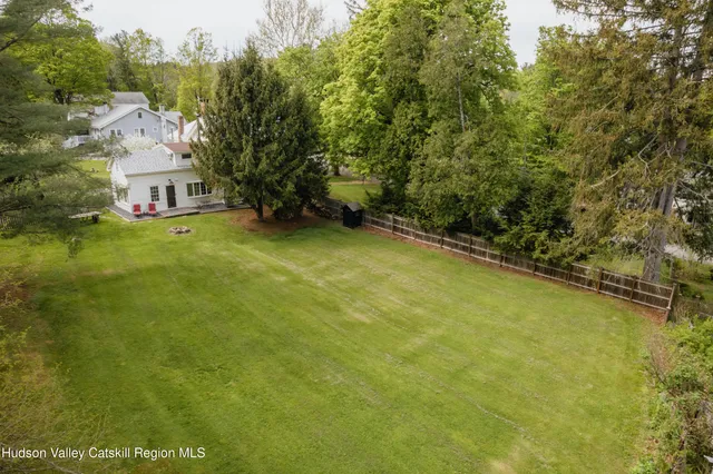 an aerial view of residential houses with outdoor space and trees