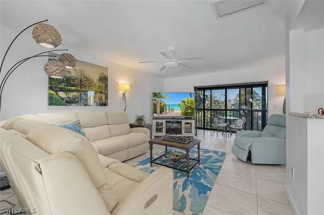 a living room with furniture and a floor to ceiling window