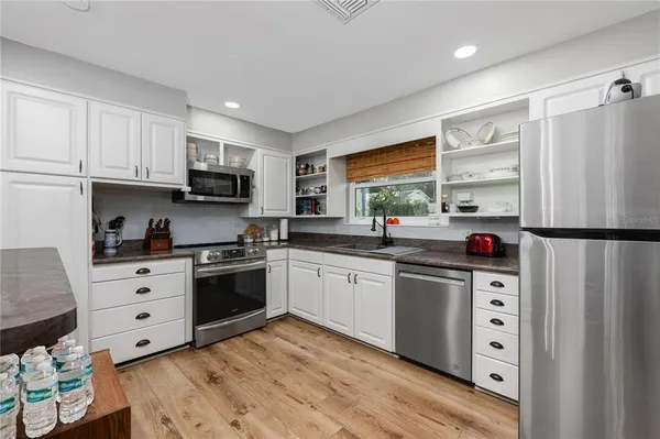 a kitchen with stainless steel appliances granite countertop a refrigerator sink and cabinets