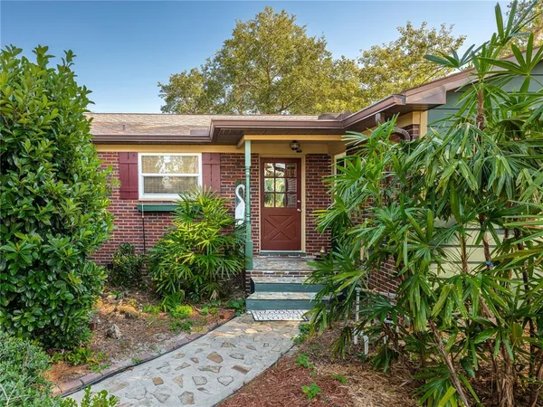 a front view of house with yard and trees around