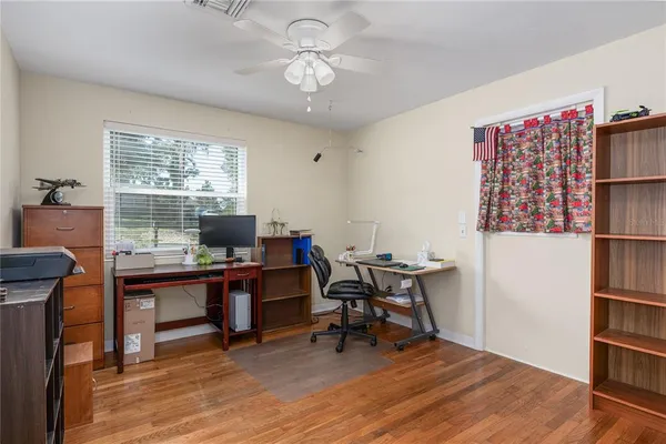 a view of a workspace with furniture and a bookshelf