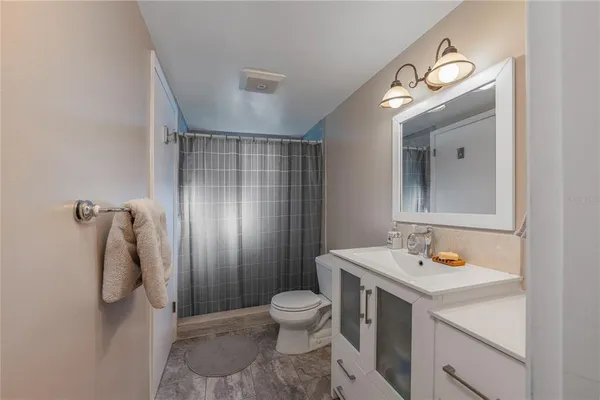 a bathroom with a sink a toilet and shower