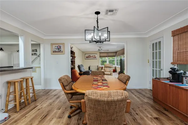 a view of a dining room with furniture a chandelier and wooden floor