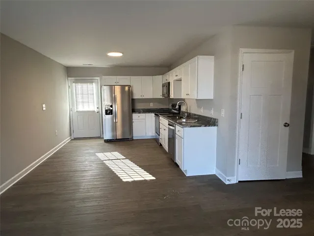 a kitchen with refrigerator and cabinets