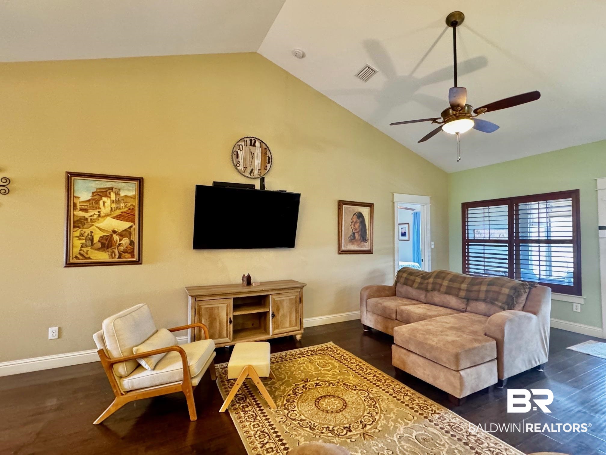1030 Crown Walk Drive Foley, AL 36535 - Photo 2 of 40 Living room featuring visible vents, lofted ceiling, a ceiling fan, dark wood-style floors, and baseboards