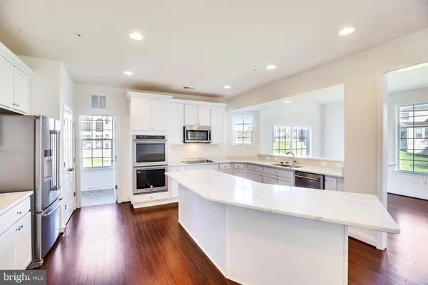a large kitchen with a large window and stainless steel appliances