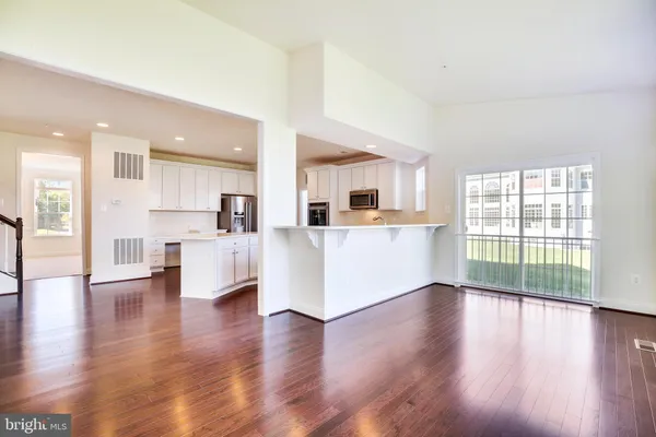 a view of a kitchen with furniture and wooden floor