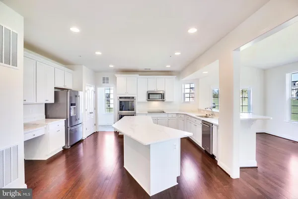 a large kitchen with a center island and stainless steel appliances