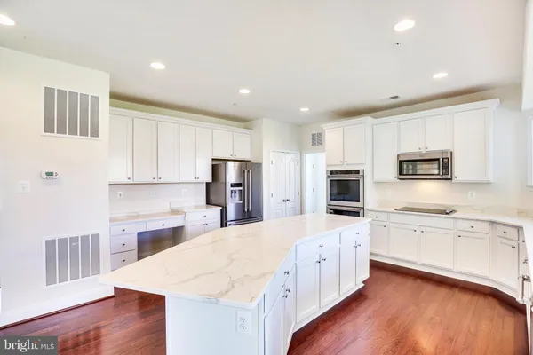 a kitchen with stainless steel appliances a refrigerator sink and microwave