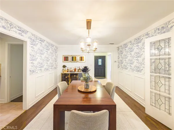 a view of a dining room with furniture a chandelier and wooden floor